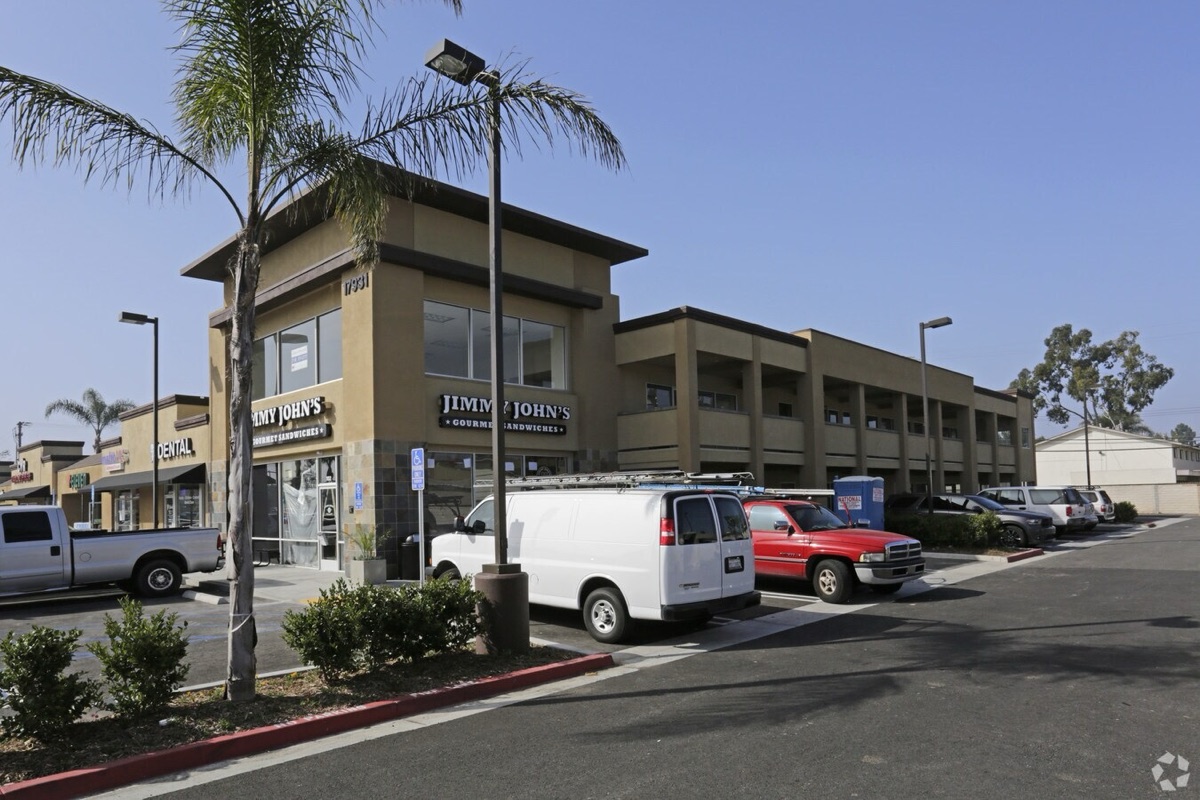 Two-story retail and office center with storefronts and parking